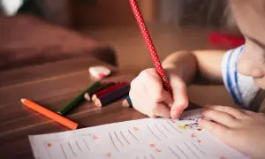Dziecko pisze, a obok leżą kredki. Czy echolalia zawsze oznacza autyzm? Niekoniecznie, to złożone zjawisko.