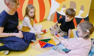 Dzieci z zaburzeniami czucia głębokiego ćwiczą koordynację, bawiąc się kolorowymi kulkami.