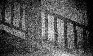 Ciemne pionowe słupki balustrady rzucają cienie, tworząc wrażenie optycznego śniegu na tle.