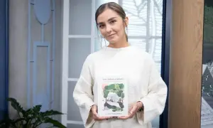 Kobieta w białym swetrze trzyma książkę "Tak działa mózg". To uwaga definicja, jak działa nasz umysł.
