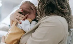 Matka tuli dziecko, które może mieć zespół Sandifera. Delikatne objęcia i troska.