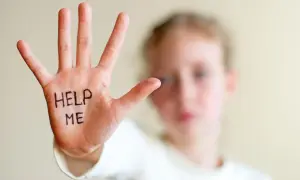 Dłoń dziecka z napisem "HELP ME" symbolizuje trudności, z jakimi mogą borykać się osoby z zespołem hiperkinetycznym, potrzebujące wsparcia.
