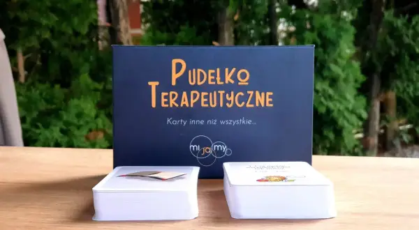 Pudełko terapeutyczne z kartami, które mogą być przykładowe formy terapii dziecka z zespołem Aspergera.