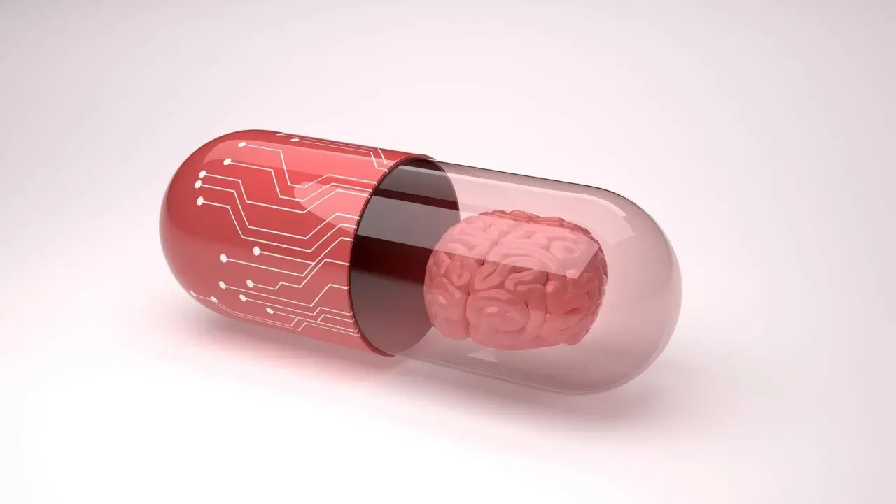 Czerwona kapsułka z obwodem drukowanym zawiera mózg, symbolizując potencjalne leki, np. inhibitory MAO, wpływające na funkcje poznawcze.