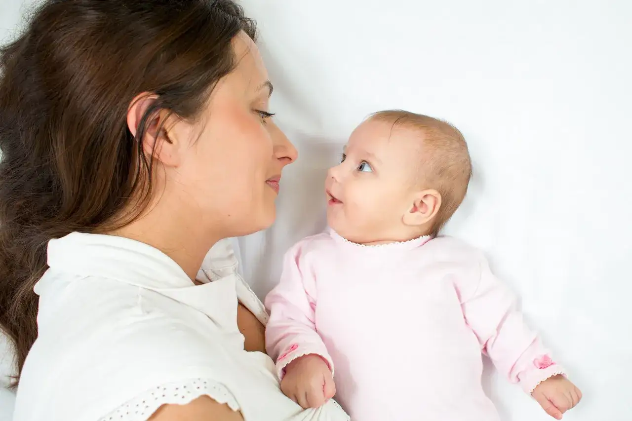 Mama i dziecko nawiązują kontakt wzrokowy, uśmiechając się do siebie.