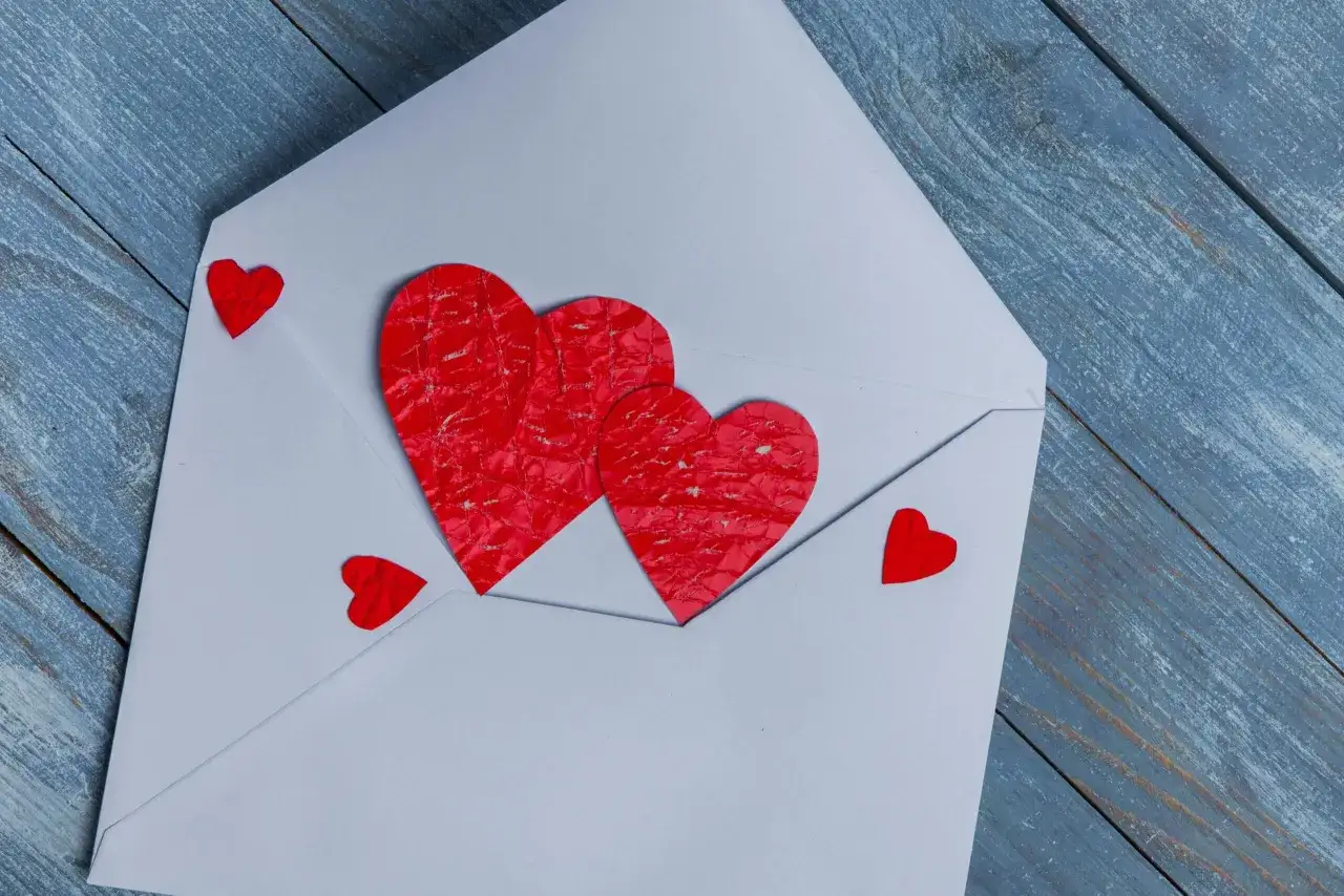 Biała koperta z czerwonymi serduszkami, jakby zapowiedź nadchodzącego love bombing.