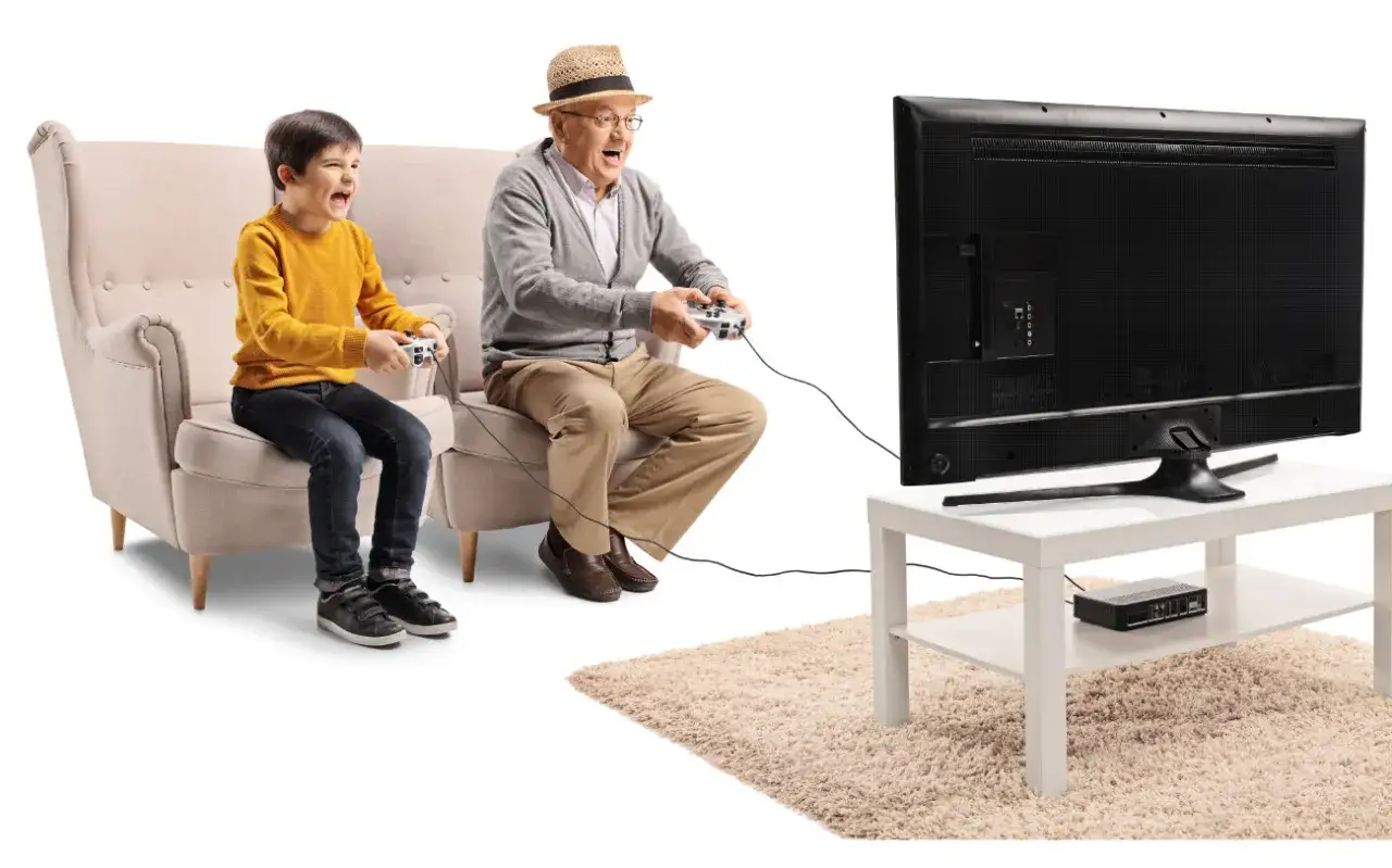 Dziadek i wnuk grają w gry logiczne dla seniorów darmowe, świetnie się bawiąc przed telewizorem.