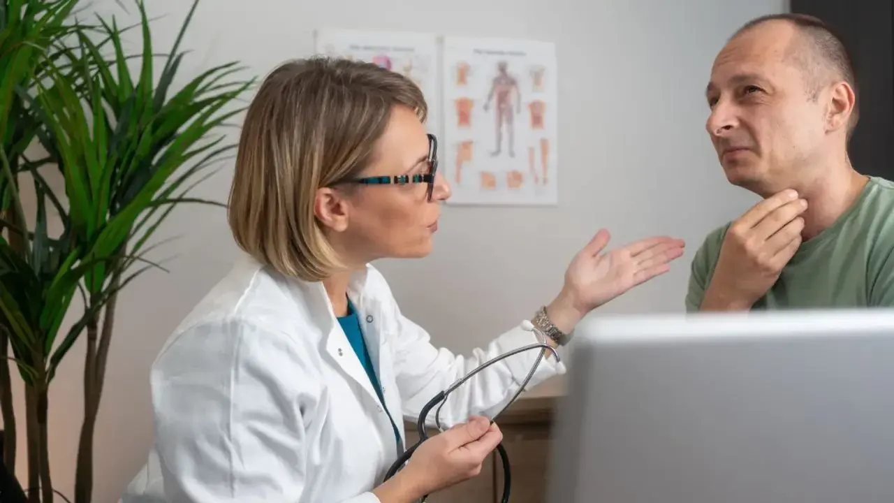 Lekarka bada pacjenta z uczuciem ucisku w gardle, który może być objawem globus histericus.