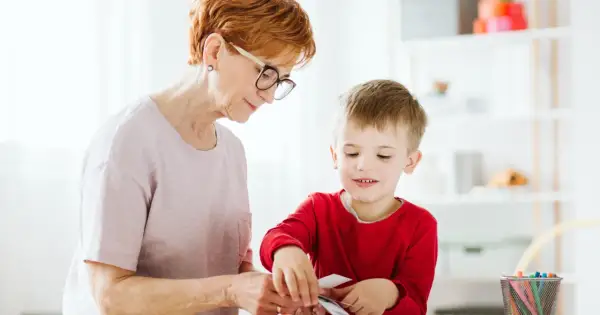 Babcia z wnukiem przeglądają karty, ucząc się rozpoznawać różne rzeczy. To świetny sposób na rozwijanie wiedzy i zapobieganie stereotypie u dzieci.