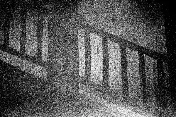 Ciemne pionowe słupki balustrady rzucają cienie, tworząc wrażenie optycznego śniegu na tle.