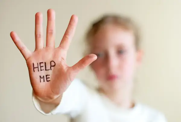 Dłoń dziecka z napisem "HELP ME" symbolizuje trudności, z jakimi mogą borykać się osoby z zespołem hiperkinetycznym, potrzebujące wsparcia.